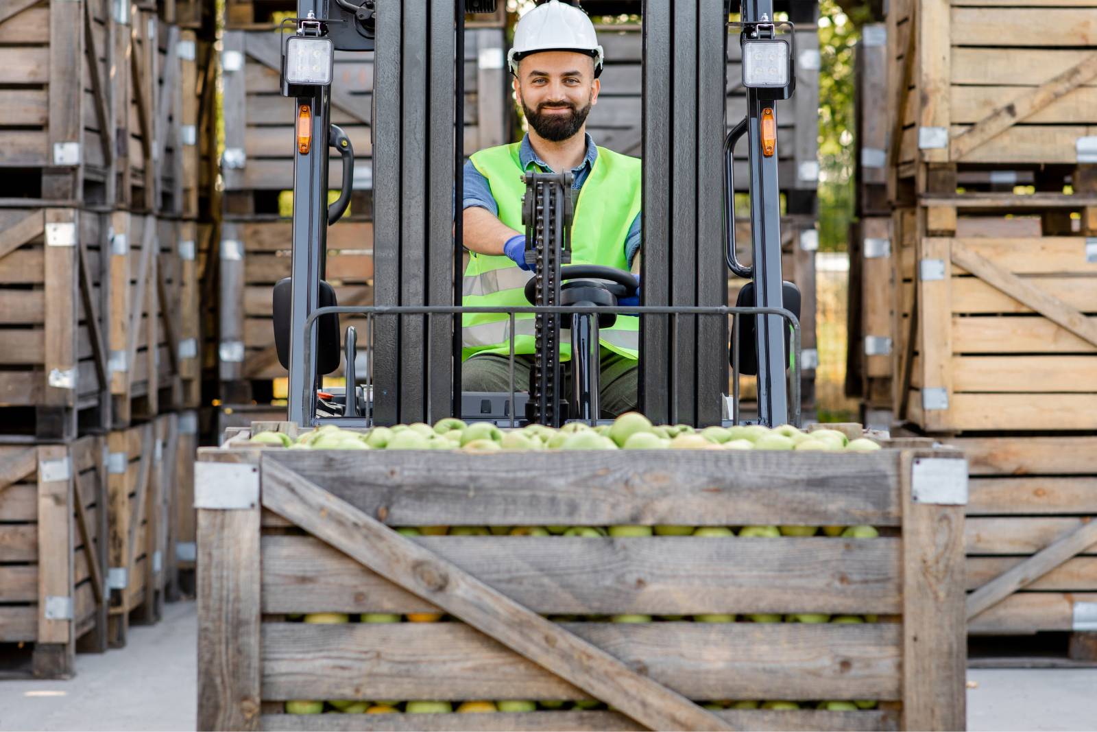 Foodservice worker moving pallet of apples