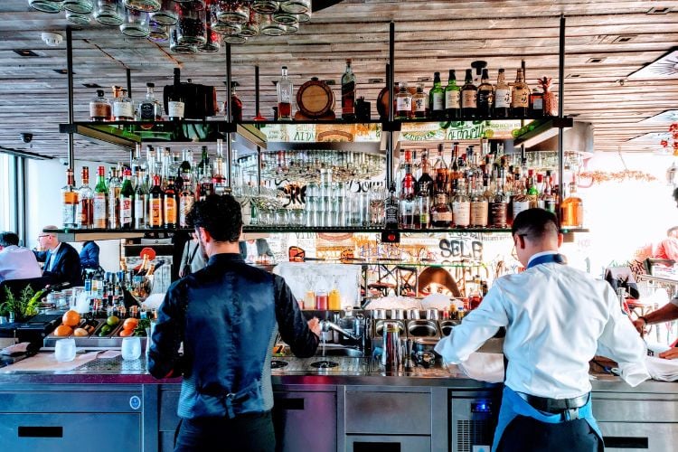 Bartenders working facing back bar